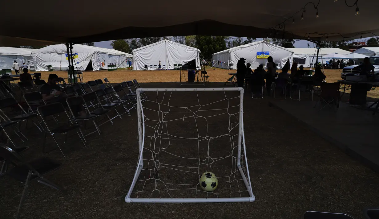 <p>Sebuah bola sepak tergeletak di gawang sepak bola portabel di sebuah kamp untuk pengungsi Ukraina di wilayah Iztapalapa di Mexico City, Selasa (24/5/2022). Mexico City akan menutup kamp yang telah menampung ratusan pengungsi Ukraina selama sebulan terakhir setelah program AS mengizinkan mereka terbang ke Negeri Paman Sam sudah beroperasi dan pihak berwenang mengatakan kamp itu tidak lagi diperlukan. (AP/Marco Ugarte)</p>