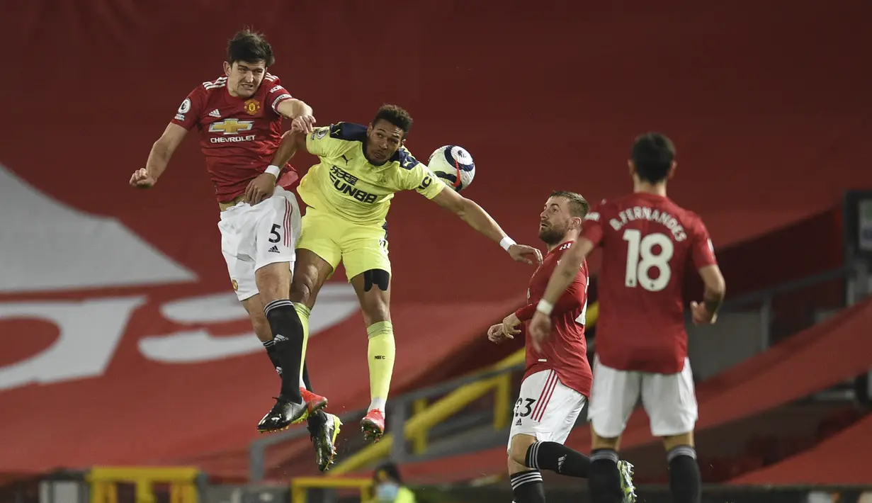 Bek Manchester United (MU), Harry Maguire menantang penyerang Newcastle United, Joelinton Newcastle pada pekan ke-25 Liga Inggris 2020/2021 di Old Trafford, Senin (22/2/2021) dini hari WIB. Manchester United (MU) sukses membungkam Newcastle dengan skor 3-1. (Oli Scarff/Pool via AP)