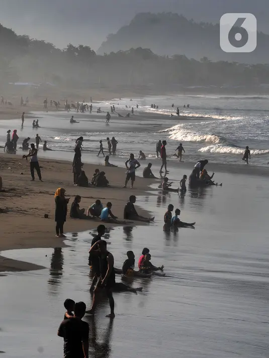 Wisatawan beraktifitas di pinggir pantai di kawasan Pantai Karang Naya, Pelabuhan Ratu, Sukabumi, Selasa (1/6/2021). Walaupun liburan lebaran telah usai sejumlah pantai di kawasan Pelabuhan Ratu masih dipadati pengunjung yang berasal dari Kota Jakarta dan Jawa Barat.(merdeka.com/Arie Basuki)