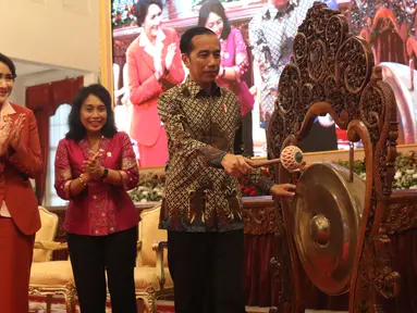 Presiden Joko Widodo (kanan) memukul gong untuk meresmikan pembukaan Kongres XXV Wanita Indonesia (KOWANI) di Istana Negara, Jakarta, Selasa (3/12/2019). Kongres membahas pemantapan strategi organisasi perempuan dalam menghadapi Revolusi Industri 4.0 dan masyarakat 5.0. (Liputan6.com/Angga Yuniar)