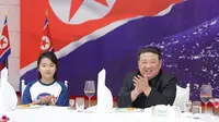 Pemimpin Korea Utara Kim Jong Un dan putrinya Ju Ae menghadiri jamuan makan di Paviliun Mulan di Pyongyang untuk merayakan peluncuran satelit mata-mata Malligyong-1. (Dok. KCNA melalui KNS/AFP)