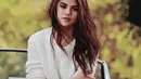 Seperti di foto ini, Selena hanya memakai denim short pantsnya dengan sweater berbahan rajutan berwarna putih. Ia pun membiarkan rambutnya yang kala itu masih panjang terurai begitu saja. (Instagram/selenagomez)