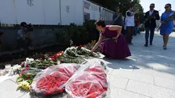 Sejumlah orang saat ingin meletakkan karangan bunga di luar Kedutaan Besar Prancis di Moskow, Rusia, (15/7). Sedikitnya 84 orang tewas dan ratusan lainnya luka akibat hantaman truk tersebut. (AFP PHOTO/Vasily Maximov)