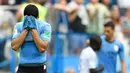 Striker Uruguay, Luis Suarez bersedih sambil menutupi wajah dengan jersey setelah kalah atas Prancis pada perempat final Piala Dunia 2018 di Nizhny Novgorod Stadium, Jumat (6/7). Timnas Uruguay tersingkir usai ditumbangkan Prancis 0-2 . (AP/Hassan Ammar)