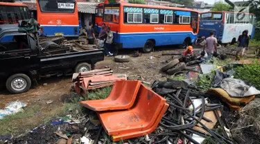 Pekerja memotong dan memisahkan sisa bagian rangka angkutan Metromini di salah satu pool Metromini, Jalan Pulogebang, Jakarta, Rabu (3/1). Satu unit bangkai metromini dihargai senilai Rp12 juta oleh pengepul besi bekas. (Liputan6.com/JohanTallo)