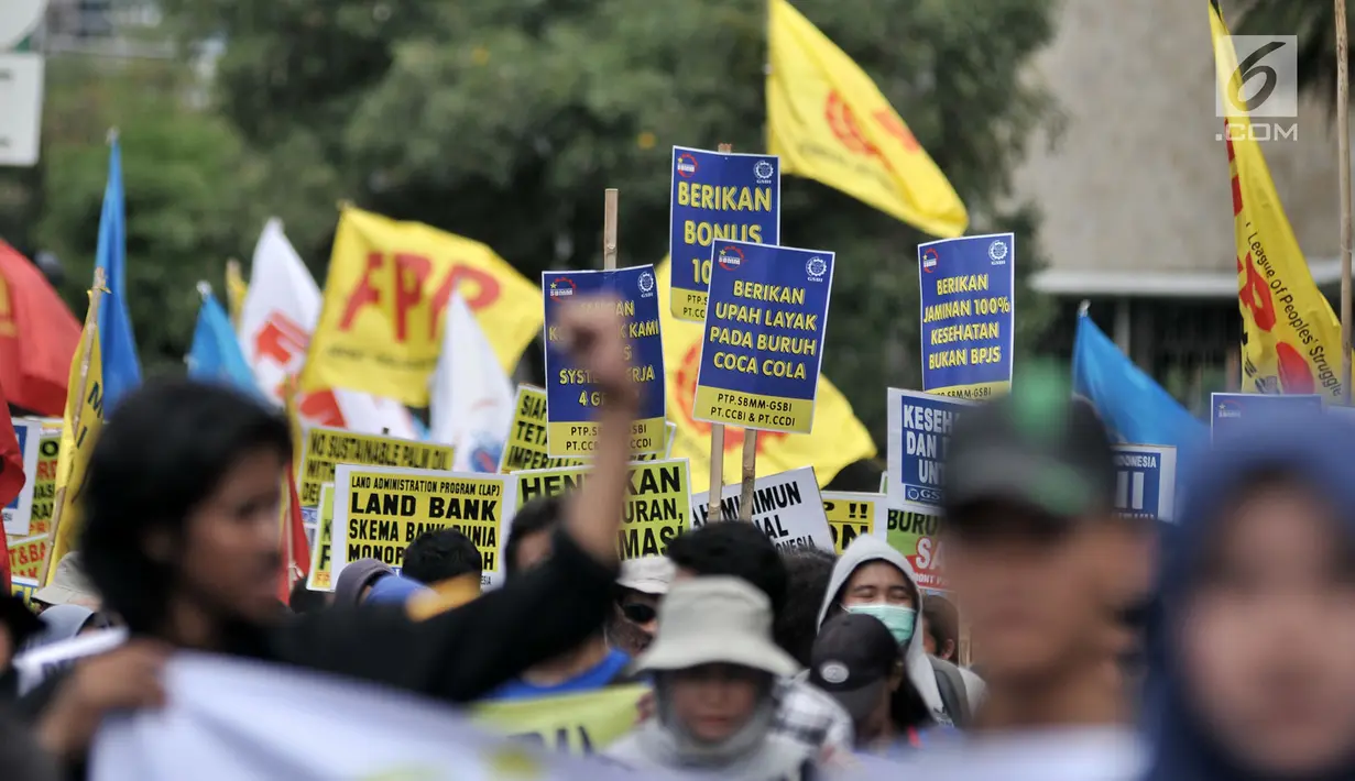 Peserta aksi dari sejumlah elemen buruh membawa poster bertuliskan tuntutan dalam peringatan Hari Buruh Sedunia di kawasan Jakarta, Rabu (1/5/2019). Buruh dari berbagai daerah di Jabodetabek serentak turun ke jalan menuju Istana Negara untuk menyuarakan 7 tuntutan. (merdeka.com/Iqbal S Nugroho)