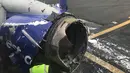 Petugas memeriksa kerusakan mesin pesawat yang membuat pesawat Southwest Airlines mendarat darurat di Philadelpia, Amerika Serikat, Selasa (17/4). Pesawat terbang selama 10 menit dengan satu mesin sebelum akhirnya mendarat darurat. (Amanda Bourman via AP)