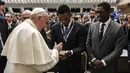 Paus Fransiskus menyalami mantan pesepak bola Kamerun, Samuel Eto'o (tengah) dan mantan pesepak bola Belanda, Clarence Seedorf  (kanan) dalam acara bertajuk "sepakbola yang kita cintai" ("Il calcio che amiamo"), yang diselenggarakan oleh surat kabar olahraga Italia "La gazzetta dello sport" dan federasi sepak bola Italia FIGC, di aula Paul-VI, Vatikan, 24 Mei 2019. (AFP/Vatican Media)