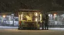 Orang-orang membeli chestnut panggang di dekat jembatan Galata saat hujan salju di Istanbul, Turki, Sabtu (12/3/2022). Salju tebal menutupi Istanbul dan mengganggu lalu lintas udara menyebabkan transportasi laut serta darat terhenti, hingga memaksa penutupan sekolah. (AP Photo/Emrah Gurel)