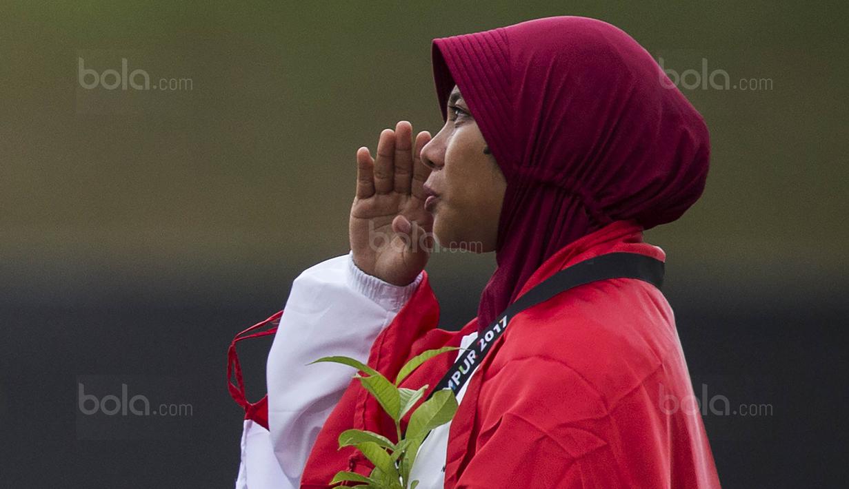 Pepanah putri Indonesia, Sri Ranti, saat prosesi pengalungan medali pada SEA Games cabang panahan nomor compound di National Sports Council, Kuala Lumpur, Rabu (16/8/2017). Dirinya meraih emas pertama untuk Indonesia. (Bola.com/Vitalis Yogi Trisna)