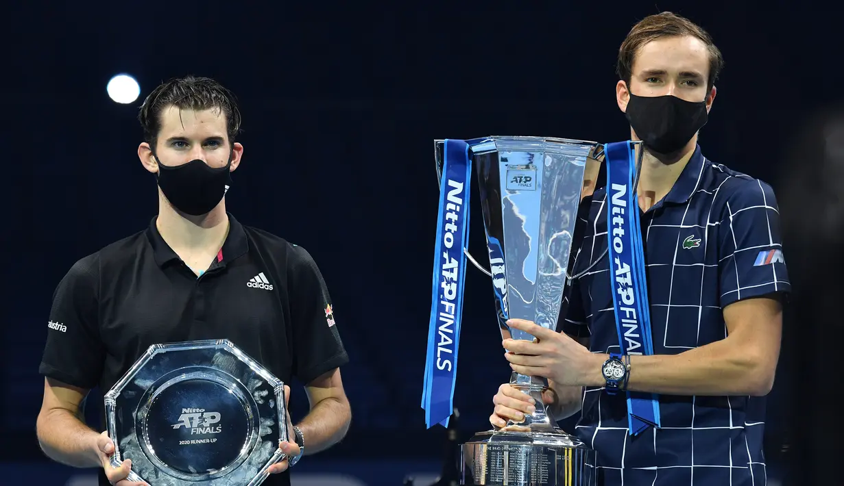 Petenis Rusia, Daniil Medvedev (kanan), berfoto dengan trofi juara usai partai final tunggal putra Turnamen Tenis ATP Finals 2020 di O2 Arena, London, Inggris, Minggu (22/11/2020). Medvedev meraih juara usai mengalahkan petenis Austria, Dominic Thiem dengan skor 4-6, 7-6 (2), 6-4. (AFP/Glyn Kirk).