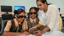 Seorang instruktur membantu para siswa disabilitas netra dalam menggunakan kacamata pintar berteknologi Artificial Intelligence (AI) di sebuah sekolah tunanetra di Hyderabad, India pada Jumat 22 November 2024. (NOAH SEELAM/AFP)