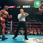 Mike Tyson dan Evander Holyfield kembali berduel di MGM Grand Garden Arena, Las Vegas pada 28 Juni 1997. Akan tetapi, laga akbar ini harus dihentikan pada ronde ketiga, karena Tyson menggigit kuping Holyfield. (AFP/JEFF HAYNES)