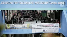 Pedagang berjualan di Jembatan Penyeberangan Multiguna (JPM) atau Skybridge Tanah Abang, Jakarta, Rabu (23/1). Ombudsman DKI Jakarta menyarankan Gubernur DKI Jakarta Anies Baswedan memperluas Skybridge Tanah Abang. (Liputan6.com/Faizal Fanani)