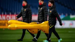 Anggota staf tim China menghadiri sesi latihan di Stadion Saitama, Jepang, Rabu (26/1/2022). China butuh 3 angka di laga ini. Wu Lei dan kawan-kawan masih ada di urutan 5 klasemen Grup B dengan raihan 5 poin. (AFP/Philip Fong)
