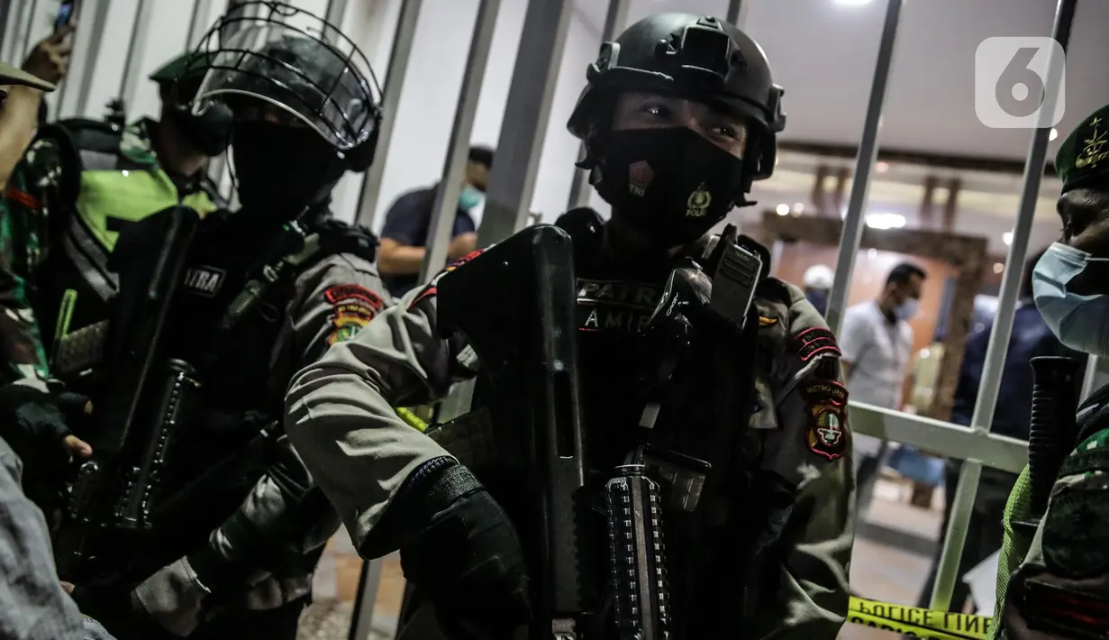 Polisi berjaga di lokasi bekas Sekretariat Markas Front Pembela Islam di Petamburan, Jakarta, Selasa (27/4/2021). Berdasarkan keterangan polisi, Munarman diduga menggerakkan orang lain untuk melakukan tindak pidana terorisme. (Liputan6.com/Faizal Fanani)