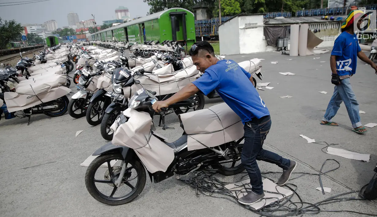 Pekerja menyiapkan motor yang akan dikirim menggunakan kereta di Stasiun Pasar Senen, Jakarta, Jumat (23/6). (Liputan6.com/Faizal Fanani)