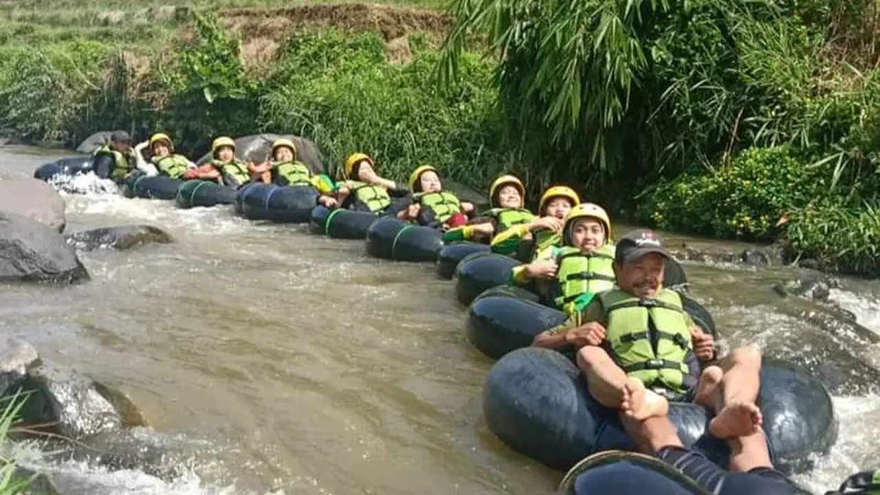 Salah satu rombongan pengunjung tengah menikmati sensasi river tubing di kawasan wisata air Sindangkasih, Cilawu Garut, Jawa Barat. (Liputan6.com/Jayadi Supriadin)