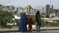 Warga Afghanistan berjalan di sebuah jalan di Kabul, pada Minggu (22/8/2021). Taliban merebut kembali kendali Afghanistan, hampir dua dekade setelah mereka digulingkan koalisi pimpinan AS. (AP Photo/ Rahmat Gul)