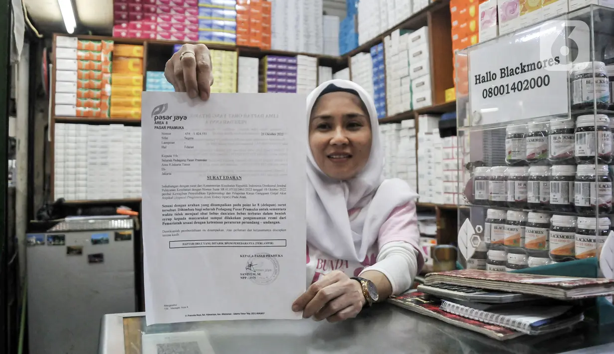 Pedagang menunjukkan surat imbauan terkait larangan penjualan lima merek obat sirup anak di Pasar Pramuka, Jakarta Timur, Minggu (23/10/2022). Untuk diketahui, saat ini para pedagang farmasi di Pasar Pramuka sudah tidak lagi menjual lima obat sirup yang dirilis oleh Badan Pengawas Obat dan Makanan (BPOM) akibat diduga melebihi ambang batas kandungan etilen glikol (EG) dan dietilen glikol (DEG). (merdeka.com/Iqbal S. Nugroho)