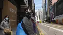 Orang-orang yang memakai masker berjalan di jalan pusat kota di Hong Kong, 23 Februari 2022. Warga Hong Kong menjadi semakin kesal dengan desakan pemerintah untuk tetap berpegang pada strategi "nol-COVID" ketika kota itu mencatat rekor jumlah kasus baru lainnya pada hari Rabu. (AP Photo/Vincent Yu)