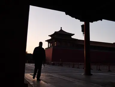 Seorang pria berjalan melewati Forbidden City atau Kota Terlarang yang ditutup di Beijing pada Selasa (4/2/2020). Mencegah korban virus corona bertambah, China menutup  banyak destinasi wisata termasuk Kota Terlarang yang ditutup untuk kunjungan wisatawan sejak 24 Januari 2020 lalu. (GREG BAKER/AFP)