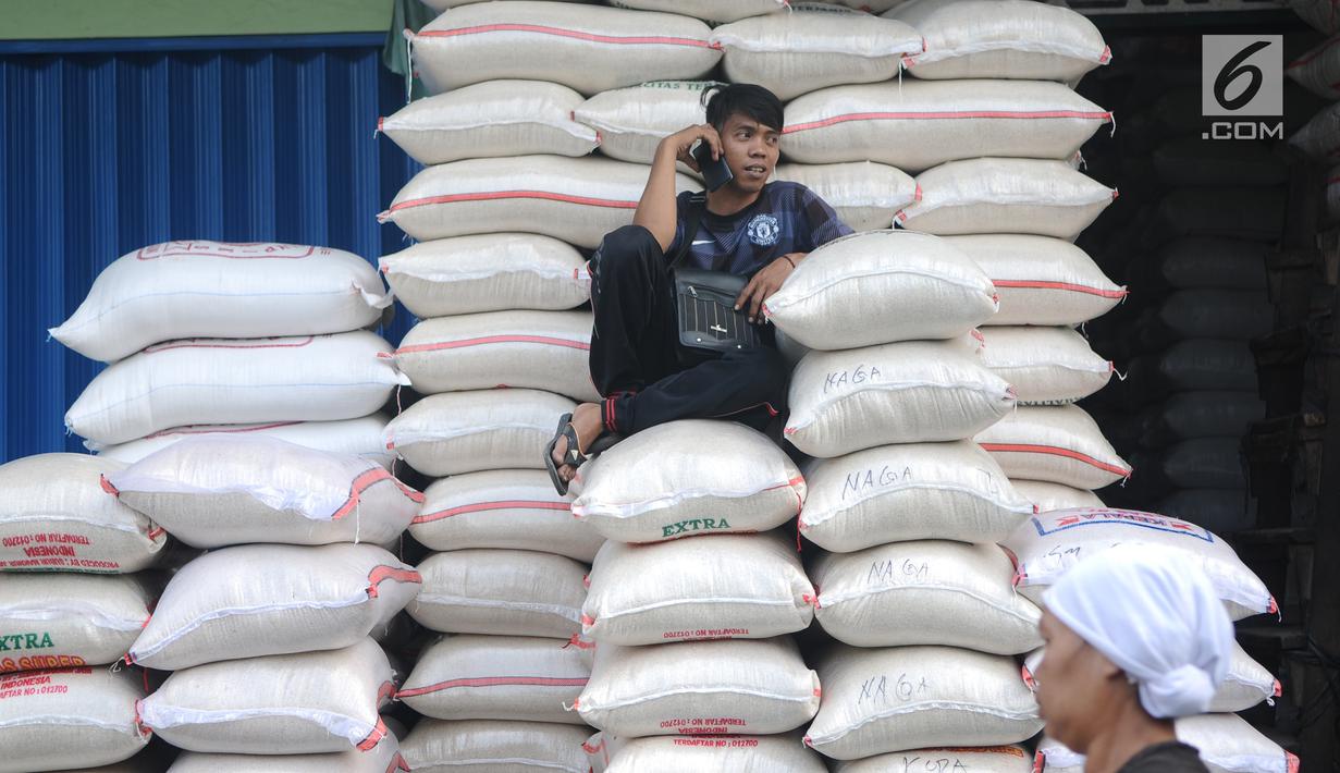 Pekerja duduk ditumpukan beras di pasar induk cipinang, Jakarta, Kamis (13/12). Direktur Pasar Induk Beras Cipinang Arief Prasetyo Adi memastikan, ketersediaan beras di pasar masih aman jelang Natal dan Tahun Baru. (Liputan6.com/Angga Yuniar)