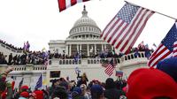 Massa pendukung Presiden Amerika Serikat Donald Trump berkumpul di luar Capitol Hill, Washington, Amerika Serikat, Rabu (6/1/2021). Sejumlah anggota parlemen dan massa pendukung Donald Trump menyerbu Capitol Hill untuk membatalkan pemilihan presiden Amerika Serikat. (AP Photo/Shafkat Anowar)