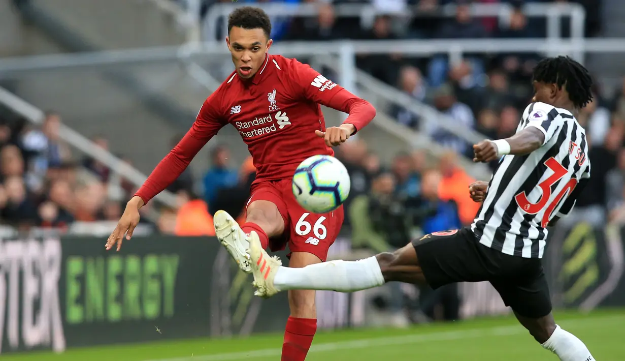 Bek Liverpool, Trent Alexander-Arnold berusaha mengumpan bola dari kawalan gelandang Newcastle United, Christian Atsu selama pertandingan lanjutan Liga Inggris di St James 'Park (4/5/2019). Liverpool menang tipis atas Newcastle 3-2. (AFP Photo/Lindsey Parnaby)