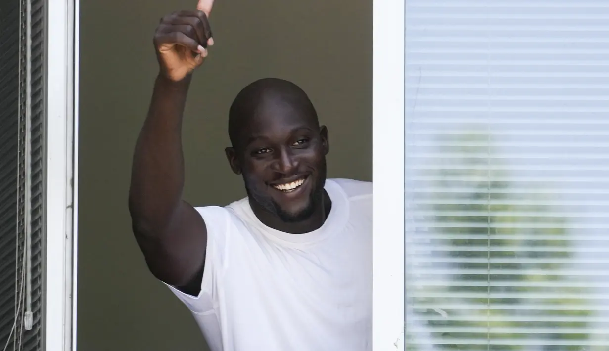 Penyerang asal Belgia, Romelu Lukaku memberikan jempol ke pendukung Inter Milan dari jendela markas Komite Olimpiade Italia di Milan, Italia, Rabu (29/6/2022). Lukaku akan bermain di Inter selama musim 2022-2023 tanpa opsi pembelian permanen. (AP Photo/Luca Bruno)