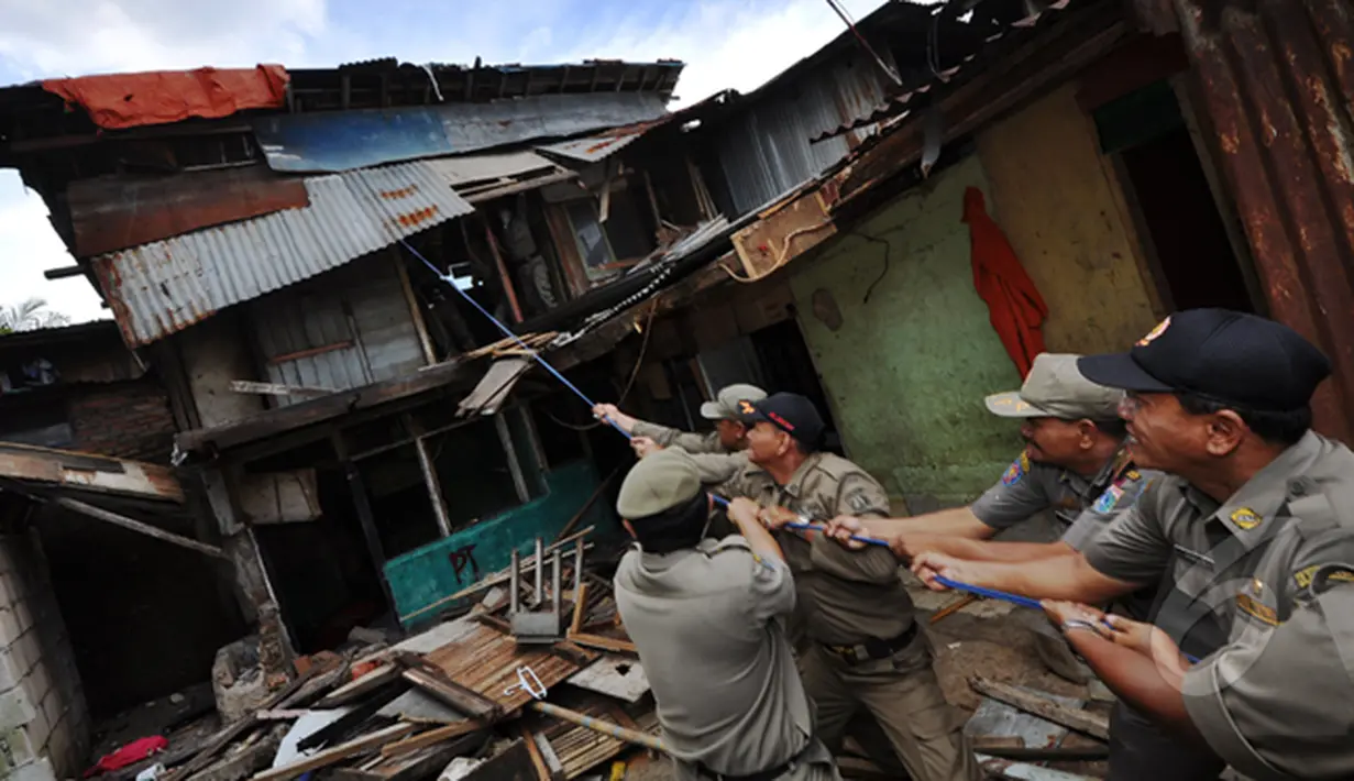 Sejumlah petugas satpol PP saat menarik bangunan liar di kawasan rusun tanah tinggi, Jakarta, Rabu (4/3/2015).  Sebanyak 10 bangunan liar di Rumah Susun (Rusun) Tanah Tinggi ditertibkan aparat satpol PP. (Liputan6.com/Faizal Fanani)