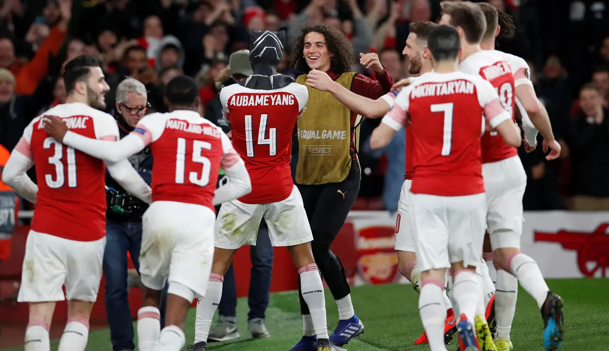 Striker Arsenal Pierre-Emerick Aubameyang (tengah) mengenakan topeng superhero Black Panther usai mencetak gol ke gawang Stade Rennes pada leg kedua babak 16 besar Liga Europa di Stadion Emirates, London, Inggris  (14/3). (REUTERS/David Klein)