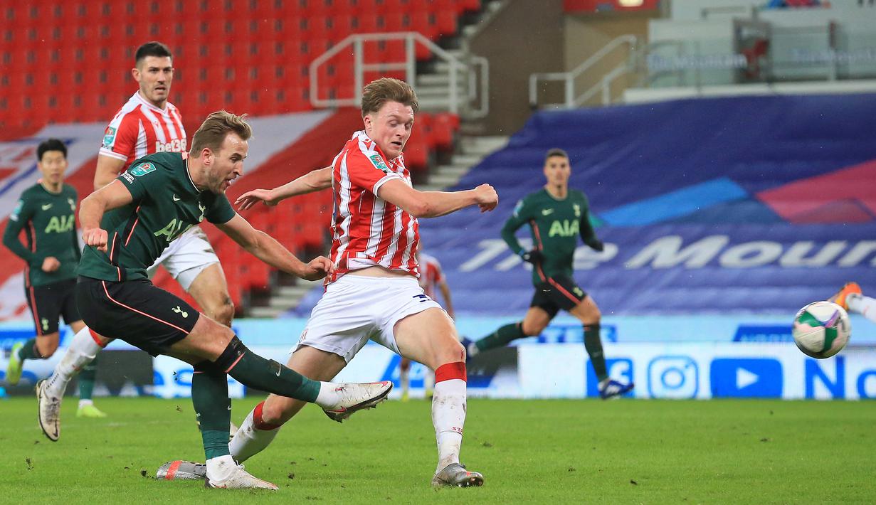 Striker Tottenham Hotspur, Harry Kane (kiri), melepaskan tendangan yang berbuah gol ketiga timnya ke gawang Stoke City dalam laga perempatfinal Piala Liga Inggris Carabao Cup di Bet365 Stadium, Rabu (23/12/2020). Tottenham menang 3-1 atas Stoke. (AFP/Lindsey Parnaby)