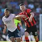 Pemain Arsenal William Saliba (kiri) berebut bola dengan pemain Bournemouth Kieffer Moore pada pertandingan sepak bola Liga Premier Inggris di Stadion Vitality, Bournemouth, Inggris, 20 Agustus 2022. Arsenal menang 3-0. (Glyn KIRK/AFP)