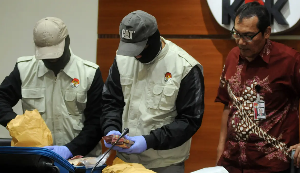 Wakil Pimpinan KPK Saut Situmorang menyaksikan barang bukti uang hasil OTT Bandung Barat di Gedung KPK, Jakarta, Rabu (11/4). Uang tersebut merupakan hasil pengutan dari Kepala Dinas oleh Bupati Bandung Barat Abubakar. (Merdeka.com/Dwi Narwoko)