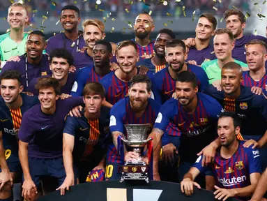 Pemain Barcelona berpose bersama trofi setelah berhasil mengalahkan Sevilla dalam pertandingan Piala Super Spanyol di Tangier, Maroko, (13/8). Barcelona berhasil mengalahkan Sevilla dengan skor 2-1. (AP Photo/Mosa'ab Elshamy)