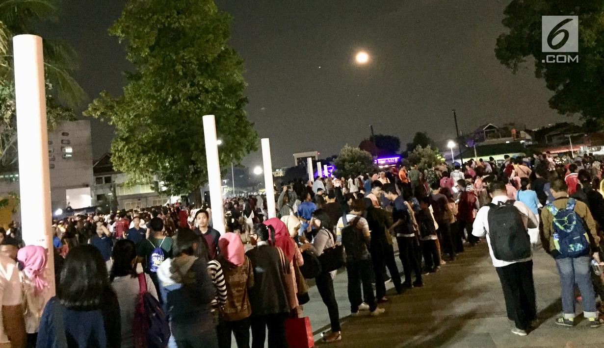 Pengunjung antre menggunakan teropong saat berlangsungnya fenomena gerhana bulan total di TIM, Jakarta, Rabu (31/1). Dalam acara ini ribuan pengunjung antusias untuk melihat langsung  fenomena Super Blue Blood Moon. (Liputan6.com/Immanuel Antonius)