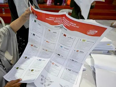 Para staf melipat surat suara pemilihan umum Indonesia 2024 di Gudang Logistik Komisi Pemilihan Umum (KPU) Denpasar, Bali, pada 14 Desember 2023. (SONNY TUMBELAKA/AFP)