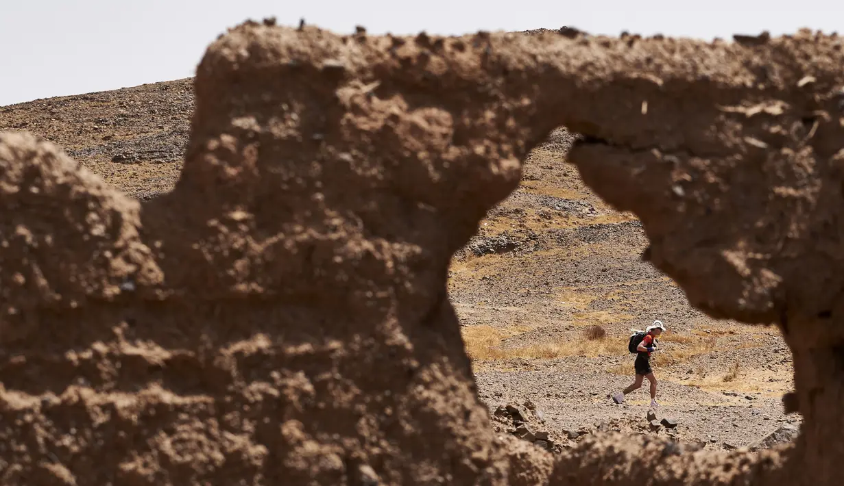 Seorang peserta berlari saat mengikuti kejuaraan marathon des Sables di gurun Sahara, Maroko, (10/4). Peserta akan menempuh jarak sekitar 257 kilometer melintasi panasnya gurun Sahara. (AFP PHOTO/JEAN-PHILIPPE Ksiazek)