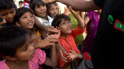 Anak-anak pengungsi Rohingya berdesakan berebut makanan di kamp pengungsi Balukhali, 50 kilometer dari Cox's Bazar, Bangladesh, Rabu (17/1). Sekitar 655.000 orang Rohingya telah melarikan diri ke Bangladesh sejak Agustus 2017. (AP Photo/Manish Swarup)