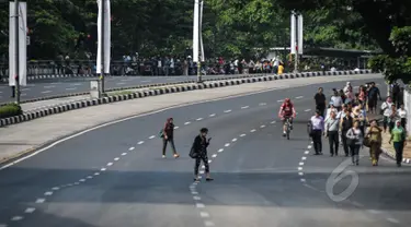 Sejumlah karyawan berjalan kaki untuk menuju kantornya di sekitar kawasan Bundaran HI, Jakarta, Rabu (22/4/2015). Sejumlah jalan utama di Jakarta ditutup total untuk sementara waktu terkait puncak Konferensi Asia-Afrika (KAA). (Liputan6.com/Faizal Fanani)