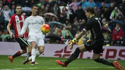  Cristiano Ronaldo saat mencetak gol ke gawang Athletic Bilbao yang dikawal Gorka Iraizoz (kanan) pada lanjtan La Liga Spanyol pekan ke-24 di Stadion Santiago Bernabeu,  Madrid, Sabtu (13/2/2016).  (AFP / Curto De La Torre)