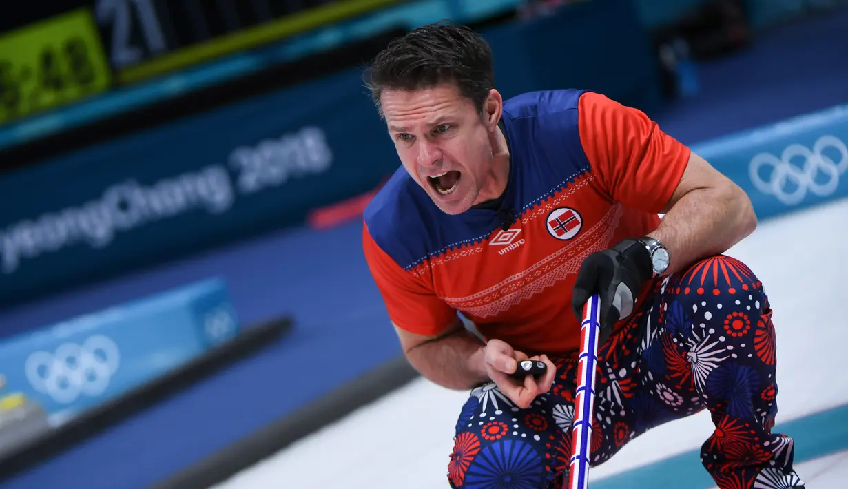 Atlet curling asal Norwegia, Thomas Ulsrud berteriak ke rekannya saat melawan Denmark pada perhelatan Olimpiade Musim Dingin Pyeongchang 2018, Minggu (18/2). Atlet curling tersebut mengenakan celana bergambar bunga putih, merah dan biru. (WANG Zhao/AFP)