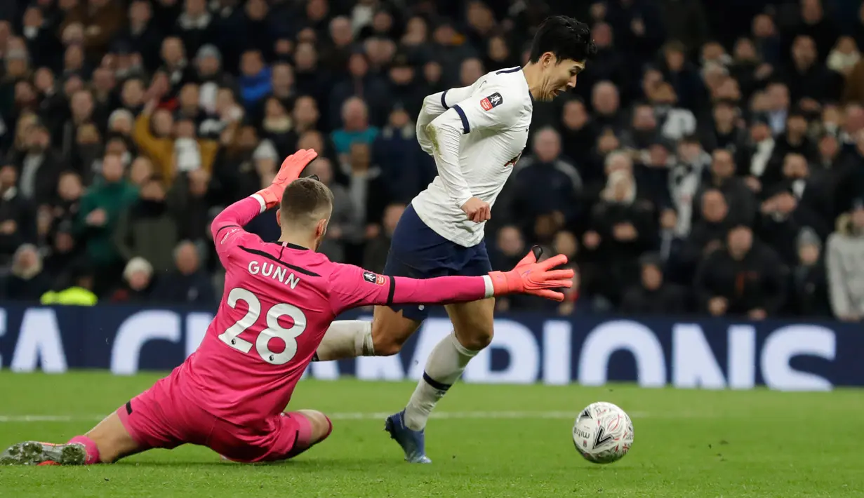 Kiper Southampton Angus Gunn (kiri) melakukan pelanggaran terhadap pemain Tottenham Hotspur Son Heung-min pada pertandingan ulangan babak keempat Piala FA di Tottenham Hotspur Stadium, London, Inggris, Rabu (5/2/2020). Tottenham Hotspur menang 3-2. (AP Photo/Kirsty Wigglesworth)