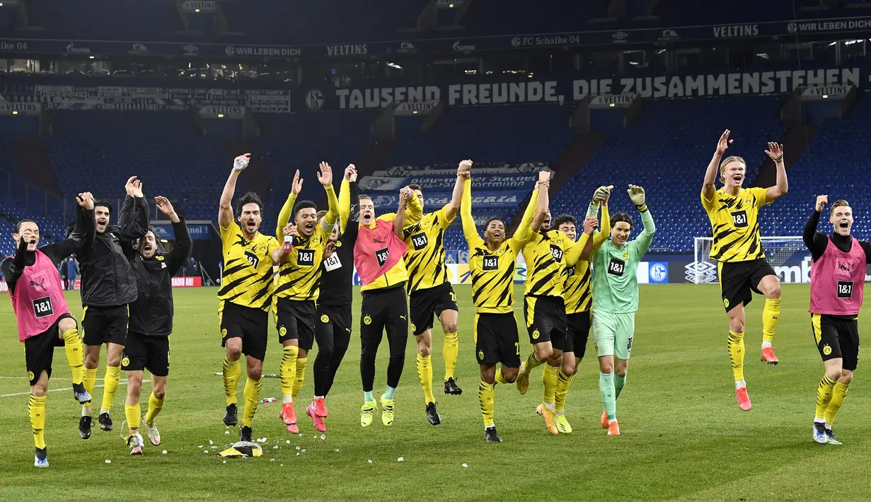 Para pemain Borussia Dortmund merayakan kemenangan 4-0 atas Schalke usai berakhirnya laga lanjutan Liga Jerman 2020/21 pekan ke-22 di Veltins Arena, Sabtu (20/2/2021). (AP/Martin Meissner/Pool)