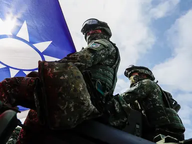 Tentara yang memegang bendera Taiwan terlihat saat latihan peningkatan kesiapsiagaan mensimulasikan pertahanan terhadap gangguan militer China jelang Tahun Baru Imlek di Kota Kaohsiung, Taiwan, 11 Januari 2023. China memperbarui ancamannya untuk menyerang Taiwan dan memperingatkan bahwa negara tersebut telah "bermain api". (AP Photo/Daniel Ceng)