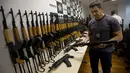 Polisi Brasil memegang senapan serbu yang disita saat konferensi pers di Rio de Janeiro, 1 Juni 2017.  Kepolian Rio de Janeiro memperkirakan senjata itu akan dijual seharga USD1,5 juta atau sekitar Rp19,9 miliar di pasar Brasil (AP Photo/Silvia Izquierdo)
