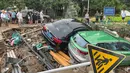 Mobil-mobil yang rusak bertumpuk pada puing-puing setelah hujan lebat melanda kota Zhengzhou yang menyebabkan banjir di provinsi Henan, China tengah (21/7/2021). Luapan sungai menggenangi jalan-jalan dan membuat kendaraan terbawa arus setelah curah hujan 200 mm turun dalam satu jam. (AFP/STR)