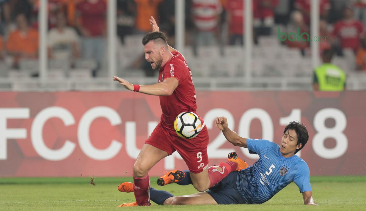Pemain Persija Jakarta, Marko Simic (kiri) gagal melewati  pemain JDT pada laga grup H Piala AFC 2018 di Stadion Utama Gelora Bung Karno, Jakarta, Selasa (10/4/2018). Persija Jakarta menang 4-0.  (Bola.com/Nick Hanoatubun)