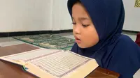 Zoi, anak Kelas 2 SD yang merupakan santriwati Pondok Pesantren Bustanul Qur'an Desa Pakikiran, Kecamatn Susukan Banjarnegara saat membaca Al-Qur'an. (Liputan6.Com/Nugroho Purbo)